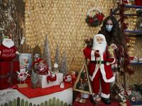 A Palestinian shop-owner arranges Christmas decorations at her shop in the West Bank city of Bethlehem on December 21, 2020. HAZEM BADER / AFP
