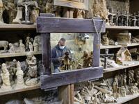 A Palestinian carpenter carves religious statues and figurines from olive wood at a shop near the Church of the Nativity, in the West Bank city of Bethlehem on December 21, 2020. HAZEM BADER / AFP