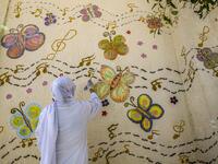 This picture taken during a government-guided tour on December 27, 2020 shows an inmate drawing a mural on a wall at al-Qanatir women's prison, at the tip of the Nile delta in Qalyoubiya province, about 30 kilometres north of Egypt's capital. Khaled DESOUKI / AFP