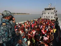 Rohingya refugees sit on a Bangladesh Navy ship as they are relocated to the controversial flood-prone island Bhashan Char in the Bay of Bengal, in Chittagong on December 29, 2020. Rehman ASAD / AFP