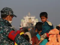 Rohingya refugees embark on a Bangladesh Navy ship as they are relocated to the controversial flood-prone island Bhashan Char in the Bay of Bengal, in Chittagong on December 29, 2020. Rehman ASAD / AFP
