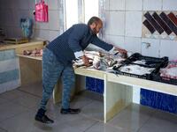 Libyan fishmonger Radwan Jibril who uses a prosthetic leg after an injury amid clashes in 2011, works at his shop in the port city of Misrata, on December 17, 2020. With Libya's health sector left in tatters by its multiple conflicts since the 2011 revolution, war-wounded Libyans are often sent abroad for treatment, at the expense of the state. However, A national centre for prostheses, being established in Misrata, already has a patient waiting list of more than 3,000 amputees