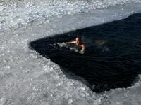 An ice swimmer swims in a frozen lake on a cold winter day in Beijing on January 6, 2021. WANG Zhao / AFP