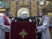 An Egyptian Coptic priest (C) holds Christmas Eve mass at the Coptic Catholic St. Mark Church in Minya city, some 245 kilometres south of the capital Cairo on January 6, 2021.   Roger ANIS / AFP