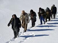In this photo taken on January 9, 2021, Hazara armed militia for the Resistance for Justice Movement, walk on a snow-covered path during a patrol against Taliban insurgents at Hisa-e-Awali Behsud district of Maidan Wardak Province. Comprising roughly 10 to 20 percent of Afghanistan's 38-million population, Hazaras have long been persecuted for their largely Shiite faith by Sunni hardliners in a country wracked by deep ethnic divisions. WAKIL KOHSAR / AFP