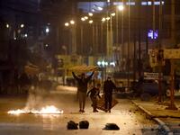 Protesters block a street during clashes with security forces in the Ettadhamen city suburb on the northwestwern outskirts of Tunisia's capital Tunis on January 17, 2021, amidst a wave of nightly protests in the North African country. FETHI BELAID / AFP