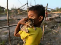 This photo taken on January 11, 2021 shows a Chin child playing with his cat in Bethel village in Hmawbi, on the outskirts of Yangon, where hundreds of members of the Chin ethnic community have settled after being displaced by fighting between Myanmar's military and the Arakan Army in the country's north.  Ye Aung THU / AFP