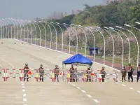 Soldiers stand guard on a blockaded road to Myanmar's parliament in Naypyidaw on February 1, 2021, after the military detained the country's de facto leader Aung San Suu Kyi and the country's president in a coup. STR / AFP