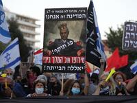  In this file photo taken on July 21, 2020, Israelis protest against Israeli Prime Minister Benjamin Netanyahu in Jerusalem. Israel's Prime Minister Benjamin Netanyahu returns to court on February 8, 2021 to formally respond to the corruption charges filed against him, as his trial enters an intensified phase six weeks before he faces re-election. Menahem KAHANA / AFP