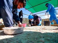Workers employed by a pilot project run by the UN cultural agency UNESCO, restore a mosaic floor at an ancient church complex, in the small town of Rihab, some 70 kilometres north of the Jordanian capital Amman, on February 9, 2021. In the ruins of the ancient Byzantine church in Jordan, local townspeople and Syrian refugees work side by side on a project that unites preserving cultural heritage and fighting poverty.  Khalil MAZRAAWI / afp