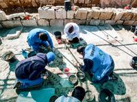 Workers employed by a pilot project run by the UN cultural agency UNESCO, restore a mosaic floor at an ancient church complex, in the small town of Rihab, some 70 kilometres north of the Jordanian capital Amman, on February 9, 2021. In the ruins of the ancient Byzantine church in Jordan, local townspeople and Syrian refugees work side by side on a project that unites preserving cultural heritage and fighting poverty.  Khalil MAZRAAWI / afp