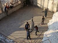 Syrian youths take part in a boxing workout held by local boxer Ahmad Dwara (unseen) inside a damaged building in the town of Atareb in the rebel-held western countryside of Syria's Aleppo province, on February 11, 2021. AAREF WATAD / AFP