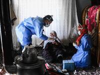In this photograph taken on February 15, 2021, Berfo Arsakay (C), 101 years old, prepares to receive a vaccine from doctor Akay Kaya (L) and nurse Yildiz Ayten (R) from the Bahcesaray public hospital vaccination team, at the village of Guneyyamac in eastern Turkey, as part of an expedition to vaccinate residents of 65 years old or above with Sinovac's CoronaVac Covid-19 vaccine. Turkey's population of more than 83 million is spread out across Europe and Asia and covers some seemingly impregnable terrain. Th