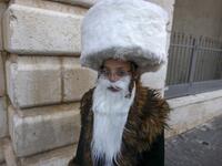 An Ultra-Orthodox Jewish child, wearing a fake beard and a shtreimel to celebrate Purim, walks in Jerusalem's the Mea Shearim neighborhood in, on February 25, 2021. Israel imposed a night-time curfew for three nights to curb the spread of the coronavirus during the Jewish holiday of Purim. The carnival-like Purim holiday is celebrated with parades and costume parties to commemorate biblical story of the deliverance of the Jewish people from a plot to exterminate them in the ancient Persian empire, as record