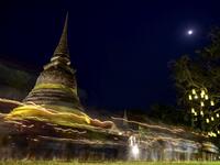 A long exposure photograph shows Buddhist monks leading a candlelight procession around Wat Traphang Thong to celebrate Makha Bucha Day in Sukhotai on February 26, 2021. Mladen ANTONOV / AFP