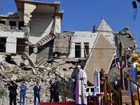 Pope Francis (C) arrives at the ruins of the Syriac Catholic Church of the Immaculate Conception 