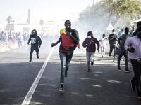 Protesters run from teargas during a protest in Dakar on March 8, 2021, after the country's opposition leader Ousmane Sonko was charged with rape. Usually considered a beacon of stability in a volatile region, deadly clashes between opposition supporters and security forces have rocked the West African state. JOHN WESSELS / AFP