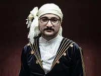 A Syrian Kurdish man in traditional attire poses for a picture 