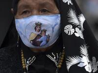 A Catholic devotee wearing a face mask as a precautionary measure against the spread of the novel coronavirus disease