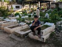 A boy sits on a grave in the Ghoraba (Strangers) cemetery