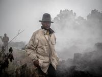 Men cross the front of the still smoking lava rocks from an eruption of the Mount Nyiragongo on May 23, 2021 in Goma in the East of the Democratic Republic of Congo. A river of boiling lava came to a halt on the outskirts of Goma Sunday, sparing the city in eastern DR Congo 