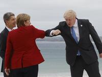 Britain's Prime Minister Boris Johnson (R) elbow-bumps Germany's Chancellor Angela Merkel as he greets her and her husband Joachim Sauer at the G7 summit in Carbis Bay, Cornwall on June 11, 2021. G7 leaders from Canada, France, Germany, Italy, Japan, the UK and the United States meet this weekend for the first time in nearly two years, for three-day talks in Carbis Bay, Cornwall