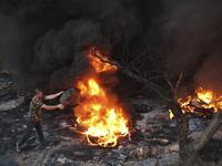 A Palestinian man sets a tire on fire in the village of Beita, south of Nablus, in the occupied West Bank, across the valley from the newly built Israeli settlers' outpost of Eviatar, on June 13, 2021. With flashing lasers, honking horns and choking smoke from burning tires, the latest tactics used by Palestinian protesters are dusk till dawn rallies to make life unbearable for Israeli settlers