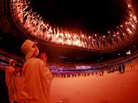 A volunteer reacts during a fireworks display at the end of the opening ceremony of the Tokyo 2020 Olympic Games, at the Olympic Stadium, in Tokyo