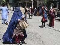 A woman wearing a burqa arrives to submit a passport application at an office in Kabul on July 25, 2021. Dozens begin lining up at the passport office in Kabul before dawn most days, and by eight in the morning the queue already stretches for a good hundred metres.