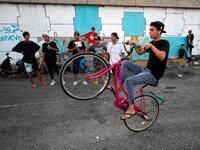 An Iraqi youth performs stunts on a bicycle in the Jadriya district of Baghdad on August 6, 2021. All dressed up and nowhere to go: many young Iraqis in Baghdad make an effort to be hip, even as they admit their country may have no future.