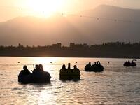 In this photograph taken on September 28, 2021 Taliban fighters ride on paddle boats at Qargha Lake on the outskirts of Kabul. "This is Afghanistan!" a Taliban fighter shouts on the pirate ship ride at a fairground in western Kabul, as his armed comrades cackle and whoop on board the rickety attraction. (Photo by WAKIL KOHSAR / AFP) / TO GO WITH: AFGHANISTAN-CONFLICT-FAIRGROUND, SCENE BY JAMES EDGAR - TO GO WITH: Afghanistan-conflict-fairground, SCENE by James EDGAR