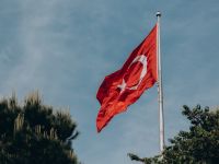 يرفرف العلم الأحمر لتركيا على خلفية السماء الزرقاء