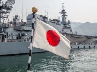 كوري، اليابان – 7 أبريل 2019: يرفرف العلم الياباني في مهب الريح أمام منشأة يابانية