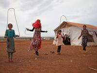 Syrian children who fled with their families from the northern countryside of Hama, jump rope in the yard of the makeshift school of "Zuhur al-Mustaqbal" (in Arabic "Flowers of the Future") in al-Jeneinah camp for displaced people in the village of Atme, in Syria's mostly rebel-held northern Idlib province, on October 1, 2018. Aaref WATAD / AFP