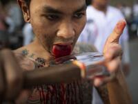 A devotee of the Loem Hu Thai Su shrine cuts his tongue on an axe as he parades during the annual Vegetarian Festival in Phuket on October 12, 2018. Jewel SAMAD/AFP