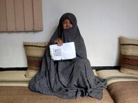 In this photo taken on October 11, 2018. Afghan housewife Fatimah, 55, poses for a picture as she holds her ID card or Tazkira registered to vote in the upcoming parliamentary election, at her House in Mazar-i-Sharif. 
FARSHAD USYAN / AFP