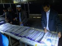 In this photo taken on October 20, 2018, Afghan Independent Election Commission (IEC) officials count ballot papers at a polling centre for the country's legislative election in Herat province. 
HOSHANG HASHIMI / AFP