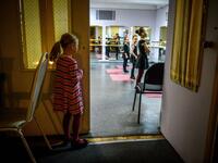 Girls attend a class at a ballet studio in Moscow on November 22, 2018. In a small studio in northern Moscow, parents and grandparents sit in a corridor waiting for children as young as three to finish their ballet class. 
Mladen ANTONOV / AFP