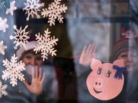 Women wave from a bus window during the New Year's car parade in the town of Vileyka about 100 km northwest from Russia's Minsk on December 29, 2018. 
Sergei GAPON / AFP