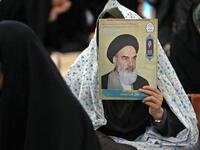 An Iranian woman holds a poster of Iran's late founder of the Islamic Republic, Ayatollah Ruhollah Khomeini
STR / AFP