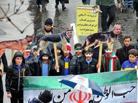 Iranian children, some with face paint in the national flag's colours, pose behind a banner depicting the national flag and with signs depicting dogs with the faces of (L to R) US President Donald Trump, Saudi King Salman bin Abdulaziz, and Israeli Prime Minister Benjamin Netanyahu.
ATTA KENARE / AFP