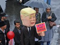 An Iranian man carries an effigy depicting US President Donald Trump carrying a sign reading in Persian "I am not bound by any commitment", during a ceremony celebrating the 40th anniversary of Islamic Revolution in the capital Tehran on February 11, 2019. 
ATTA KENARE / AFP