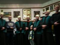 A boy looks on as he stands among Kosovo Dervishes during a ceremony in a prayer room in Gjakova
Gent SHKULLAKU / AFP