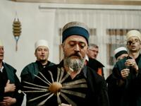 A Kosovo Dervish, adept of Sufism, a mystical form of Islam, swirls a needle before piercing his cheek during a ceremony in a prayer room
Gent SHKULLAKU / AFP