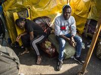 Sub-Saharan migrants sit by a make-shift tent at the Oulad Ziane migrant camp in Casablanca on March 27, 2019. 
FADEL SENNA / AFP