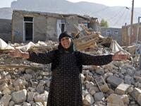 An Iranian woman gestures next to the rubble of her home in Kouik village.

(ATTA KENARE / AFP) 