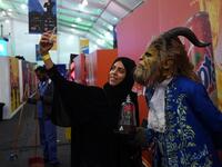 A Saudi woman uses her cell phone to take a "selfie" photograph with a cosplayer dressed as the Beast from Disney's 2017 live-action "Beauty and the Beast" film, as they attend the first ever Comic-Con Arabia event held in the capital Riyadh on November 25, 2017. 
(FAYEZ NURELDINE / AFP)