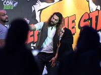 US actor Jason Momoa uses a cell phone to pose for a "selfie" photograph with a Saudi woman as they attend the first ever Comic-Con Arabia event held in the capital Riyadh on November 25, 2017. 
(FAYEZ NURELDINE / AFP)