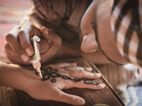 Bedouin making henna on a woman's hand. Hand decorations are usually done by a relative of the bride in her home (Shutterstock/File Photo)