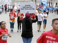 A protester holds a banner with a message against sexual assault during the 16th edition of the Beirut Marathon in the Lebanese capital on November 11, 2018. 
Marwan TAHTAH / Abaad / AFP
